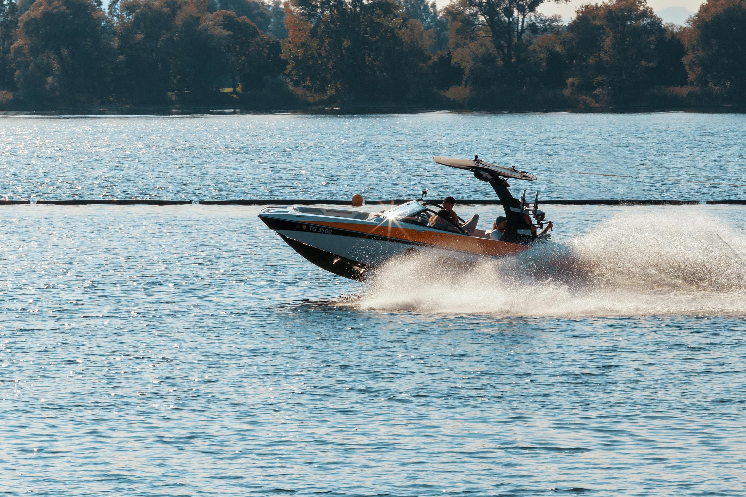 person driving black and orange speedboat